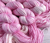 Semi-solid pink and white yarn with subtle pink speckles.  The yarn has a slight sheen due to silk content.